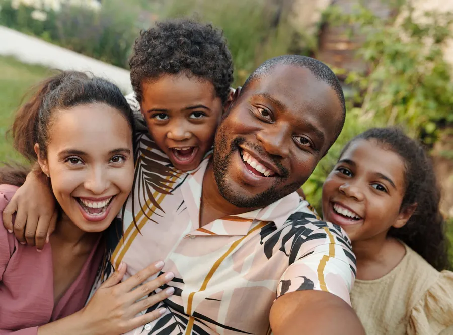 A smiling family of four outdoors